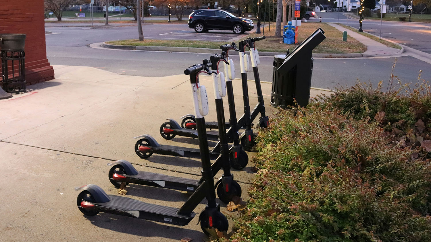 A group of electric scooters parked on a sidewalk. Can Electric Scooters Get Wet? Scooter Advice