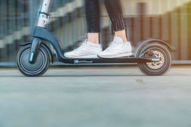 A woman is riding an electric scooter. Scooter Advice 360
