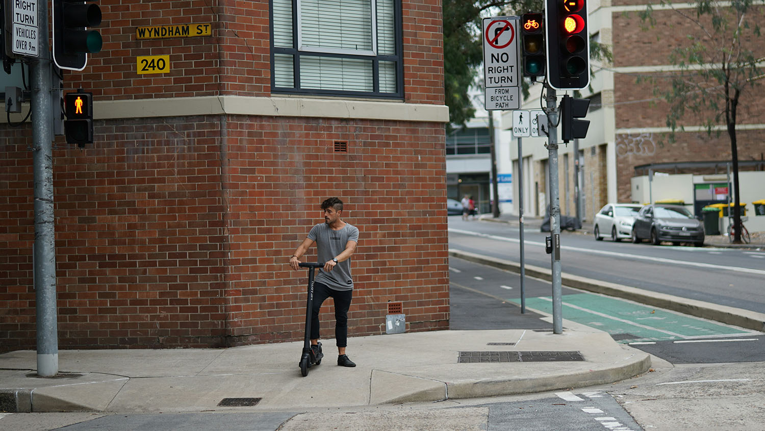 A man riding an electric skateboard on a city street. Scooter Advice