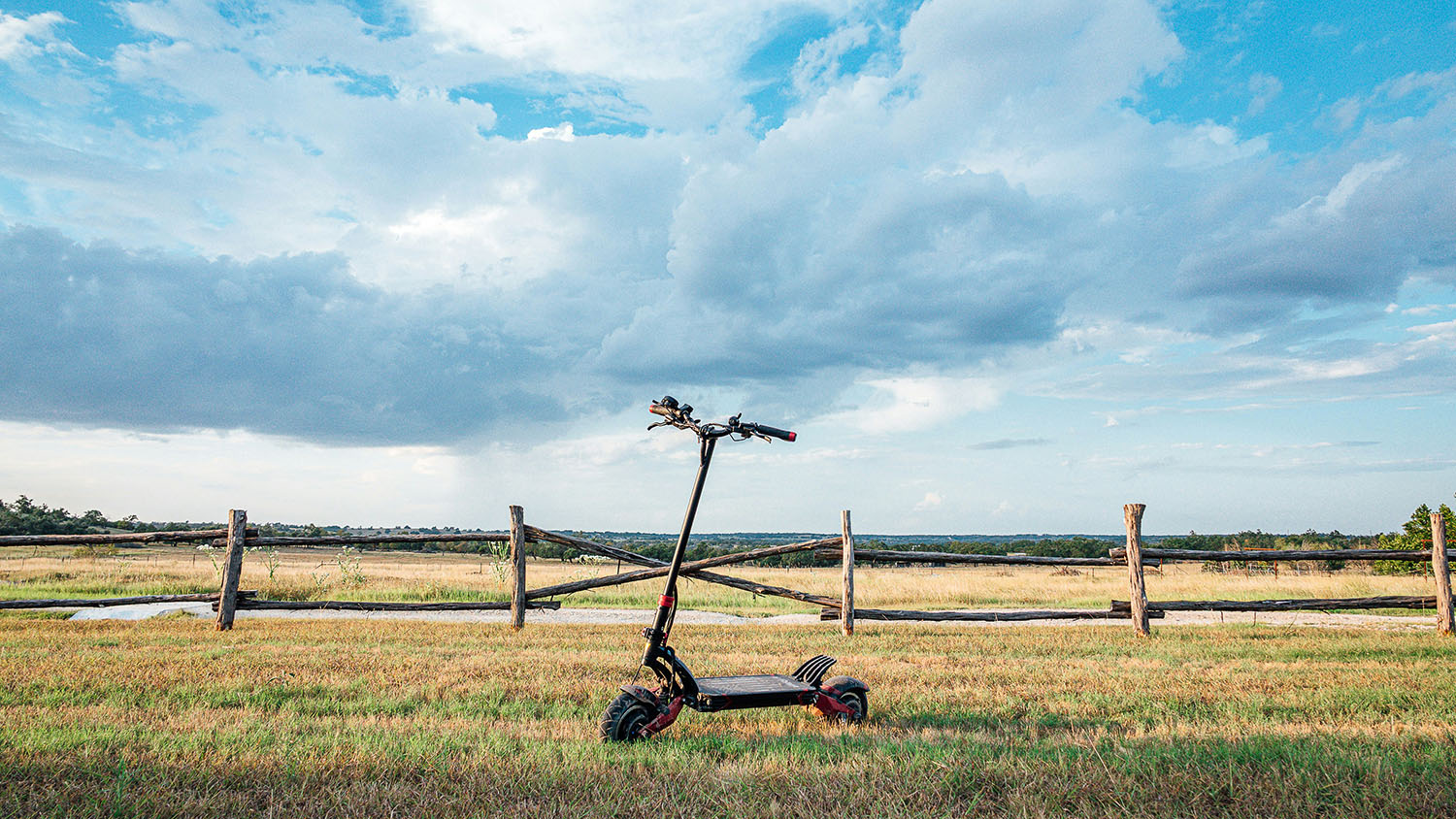 A lime scooter in a field with a fence in the background. How Fast Does a Lime Scooter Go? Scooter Advice