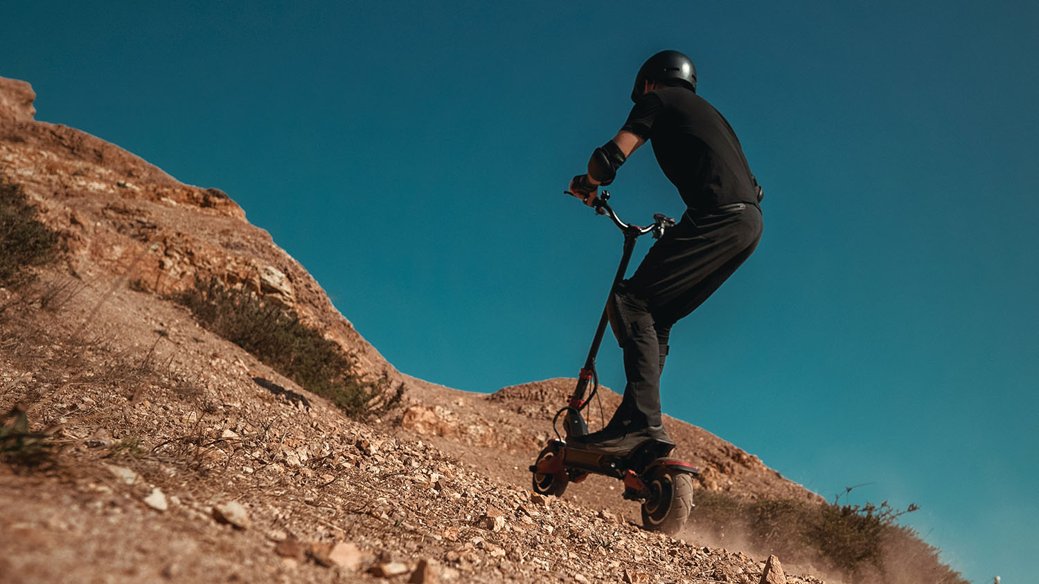 A person riding an electric scooter down a hill, showcasing the best off road electric scooter. Scooter Advice 360