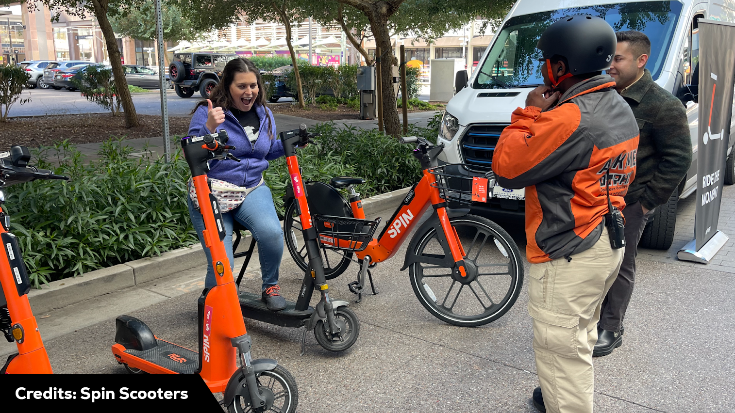 A group of people standing next to a van withscooters, demonstrating how to use Spin scooters. Scooter Advice