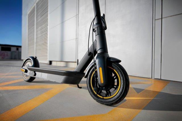 An electric scooter is parked in front of a building. Scooter Advice 360