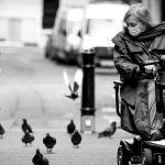 A woman effortlessly glides on her scooter through the city streets, leaving a trail of pigeons in her wake. Scooter Advice