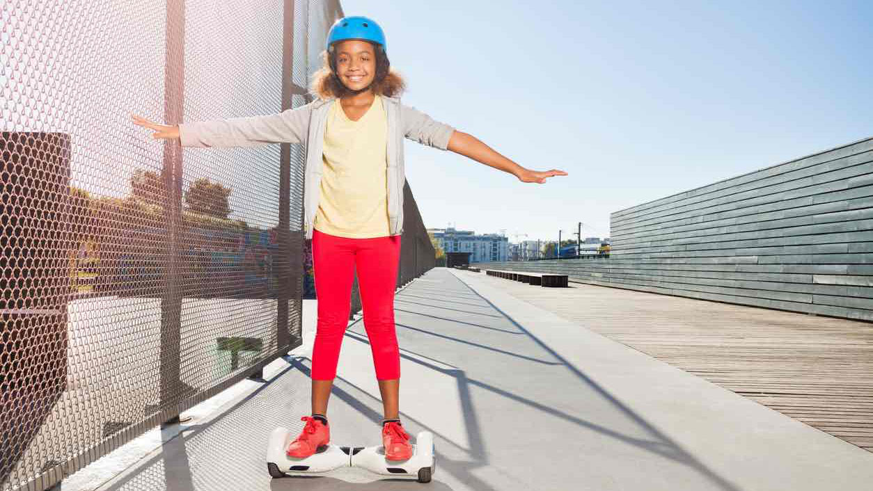 A girl is riding a hoverboard on a fence. Scooter Advice