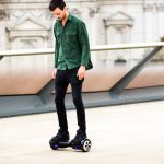 A man standing on a hoverboard. Scooter Advice