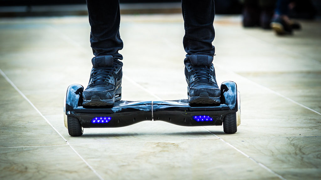 A person is standing on a hoverboard. Scooter Advice