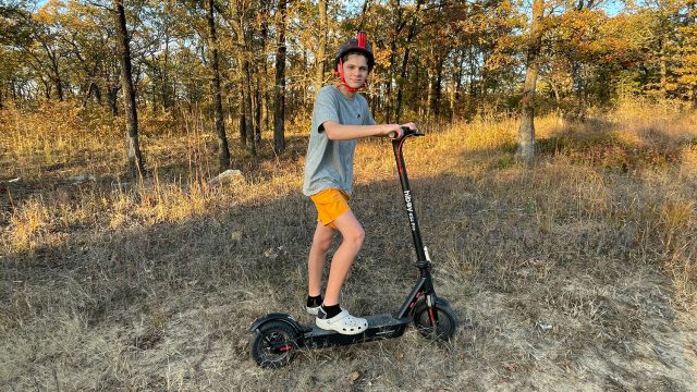 A boy riding an electric scooter in the woods. Are Electric Scooters Legal in NYC? Scooter Advice
