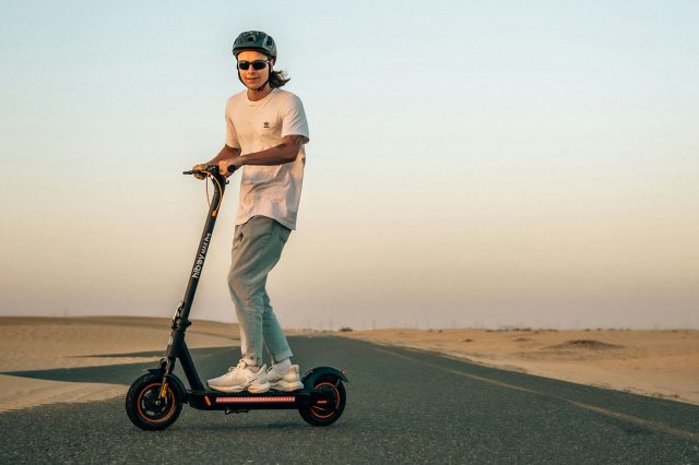 A man riding an electric scooter in the desert, searching for the reset button. Scooter Advice