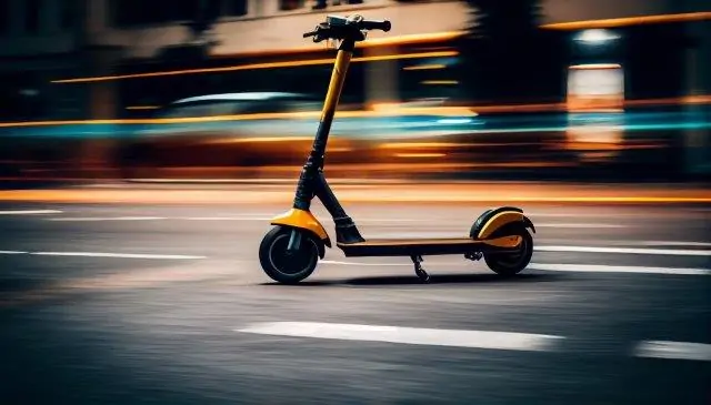 Electric scooter in motion on a city street at night with blurred lights in the background. Scooter Advice 360
